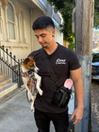 Man holding a dog on a leash in an urban setting